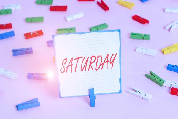 Conceptual hand writing showing Saturday. Business photo text First day of the weekend Relaxing time Vacation Leisure moment Colored clothespin papers empty reminder pink floor office pin. — Stockfoto