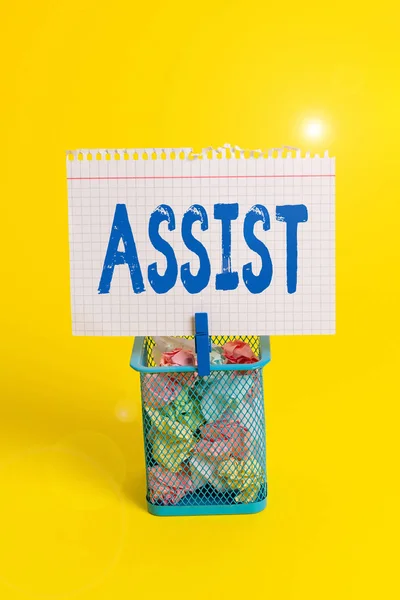 Word writing text Assist. Business concept for help them to do a job or task by doing part of the work for them Trash bin crumpled paper clothespin empty reminder office supplies yellow.
