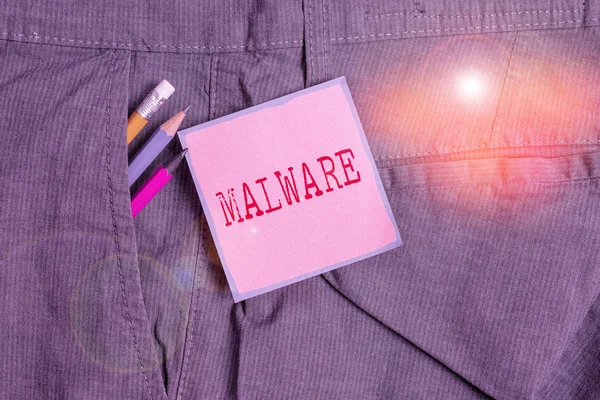 Handwriting text writing Malware. Concept meaning malicious software or file that is harmful to a computer user Writing equipment and pink note paper inside pocket of man work trousers. — Stockfoto