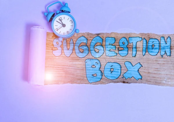 Text sign showing Suggestion Box. Conceptual photo container which showing can leave comments about something Alarm clock and torn cardboard placed above a wooden classic table backdrop.