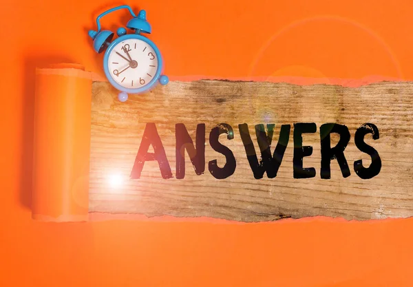 Escribir texto a mano Respuestas. Concepto significado Reacciones respuestas a preguntas declaraciones o situaciones Opciones Reloj despertador y cartón desgarrado colocado sobre un fondo de mesa clásico de madera . —  Fotos de Stock