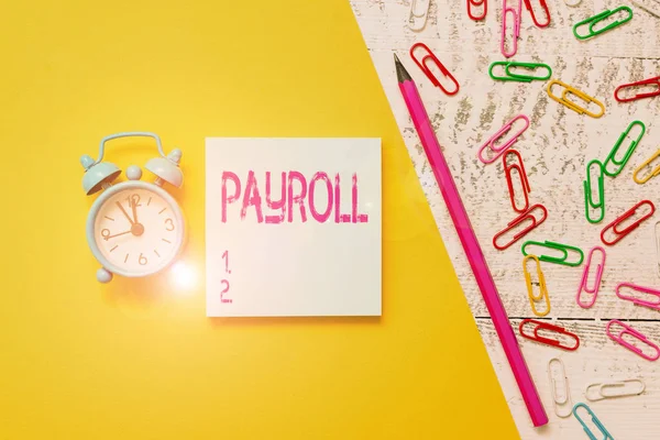 Woord schrijven tekst Payroll. Business concept voor Totale bedrag van het geld bedrijf betaalt aan medewerkers Salaris Betaling Notepad marker pen gekleurd papier vel clips wekker houten achtergrond. — Stockfoto