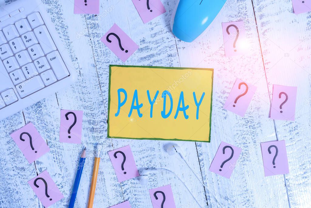 Text sign showing Payday. Conceptual photo a day on which someone is paid or expects to be paid their wages Writing tools, computer stuff and scribbled paper on top of wooden table.