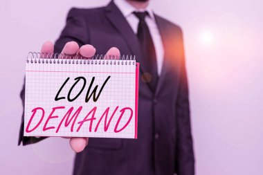 Text sign showing low demand. Conceptual photo less consumer s is desire to purchase goods and services Male human wear formal work suit office look hold mathematics book use hand.