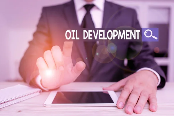 Writing note showing Oil Development. Business photo showcasing act or process of exploring an area on land or sea for oil Male human wear formal clothes present use hitech smartphone. — стокове фото