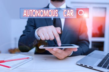 El yazısı Otomatik Otomobil. Kavram, insan iletkeni olmadan kendini yönetebilen bir araç demektir. Erkek insan resmi kıyafetler giyer. Sunum için yüksek teknoloji akıllı telefonu kullanın..