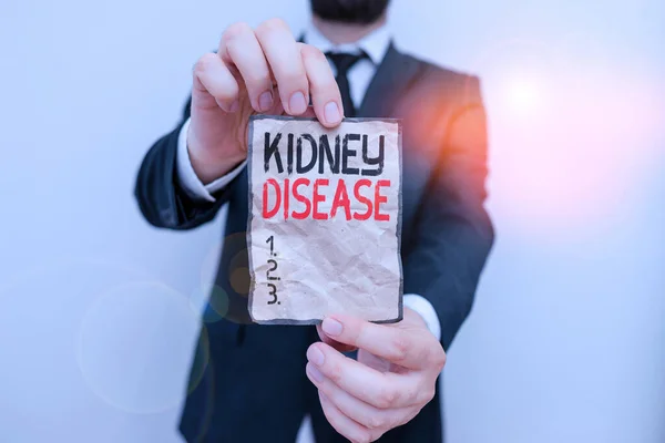 Text sign showing Kidney Disease. Conceptual photo condition characterized by a gradual loss of kidney function Male human wear formal work suit office look hold notepaper sheet use hand.