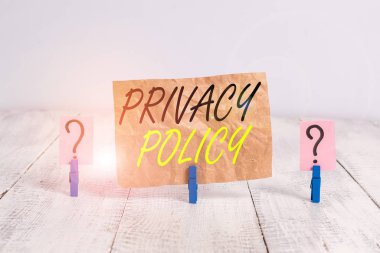 Kelime yazma gizlilik politikası. İfadeler için iş kavramı ya da müşterilere verileri açıklayan yasal bir belge Tahta masaya yerleştirilmiş ataçlarla karalanmış ve parçalanmış kağıtlar.