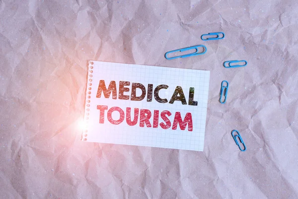 Conceptual hand writing showing Medical Tourism. Business photo showcasing traveling outside the country to receive medical care Papercraft desk square spiral notebook office study supplies.