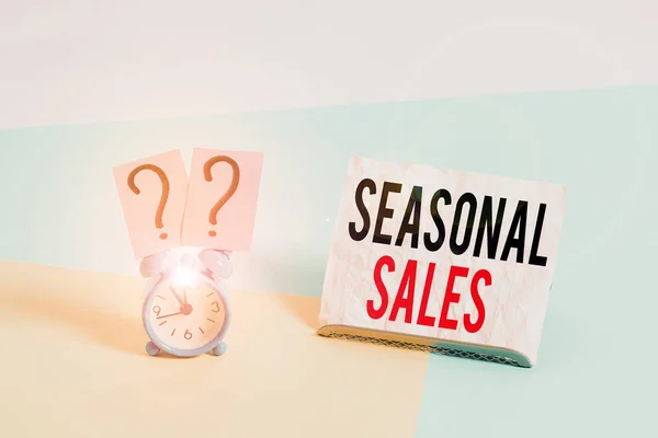 Writing note showing Seasonal Sales. Business photo showcasing Discount which is offered on goods at particular seasons Alarm clock beside a Paper sheet placed on pastel backdrop. — 스톡 사진
