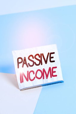 Writing note showing Passive Income. Business photo showcasing the earnings derived from a rental property and others Paper on buffer wire on soft pastel multi colours backdrop.