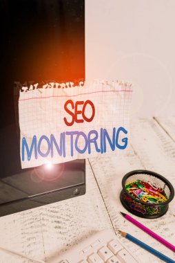 Kelime yazarı Seo Monitoring. Web sitenizin görünürlüğünü optimize etme süreci için iş konsepti Klavye ve durağanlık yakınındaki siyah bilgisayar ekranına bantlanmış Not kağıdı.