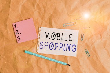Kelime yazma metni Mobil Alışveriş. Kablosuz cihazlar aracılığıyla mal ve hizmetlerin ticareti konsepti Kağıt işçiliği kağıt masa karesi sarmal defter ofis malzemeleri.