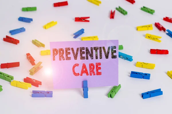 Word writing text Preventive Care. Business concept for care that you receive to prevent illnesses or diseases Colored clothespin papers empty reminder white floor background office. — Stok fotoğraf