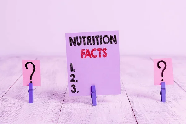 Conceptual hand writing showing Nutrition Facts. Business photo showcasing detailed information about a food s is nutrient content Crumbling sheet with paper clips placed on the wooden table. — Stok fotoğraf