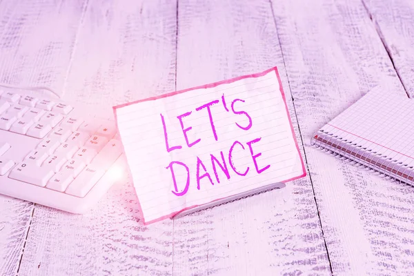 Conceptual hand writing showing Let S Is Dance. Business photo showcasing move rhythmically to music following a set sequence of steps Notepaper on wire in between computer keyboard and sheets.