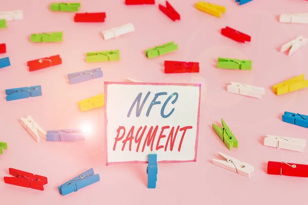 Conceptual hand writing showing Nfc Payment. Business photo showcasing contactless payment that use nearfield communication technology Colored clothespin papers empty reminder pink floor office. — Stock fotografie