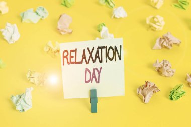 Writing note showing Relaxation Day. Business photo showcasing pleasant activity that makes you become calm and less worried Colored crumpled paper empty reminder white floor clothespin.