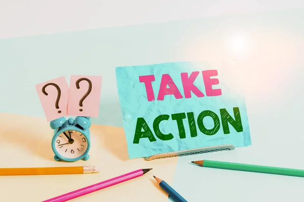 Texto de escritura de palabras Tomar acción. Concepto de negocio para hacer algo Para actuar con el fin de obtener un resultado particular Reloj despertador de tamaño mini junto a estacionario colocado inclinado sobre fondo pastel . —  Fotos de Stock