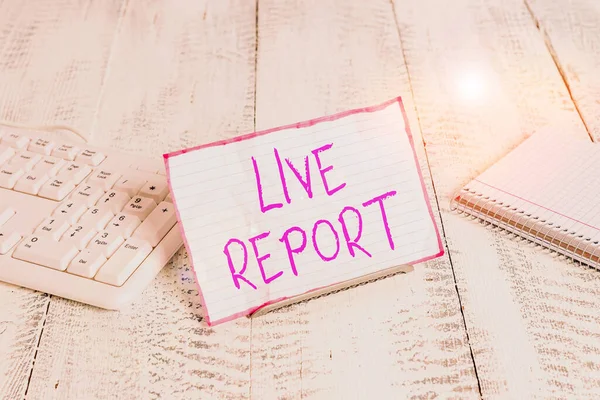 Conceptual hand writing showing Live Report. Business photo showcasing continuous stream of updates that are published in real time Notepaper on wire in between computer keyboard and sheets.