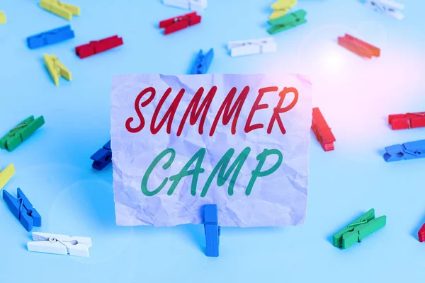 Texto escrito por palavra Summer Camp. Conceito de negócio para o programa supervisionado para crianças conduzidas durante o verão Papéis de roupa coloridos lembrete vazio piso azul fundo pino de escritório . — Fotografia de Stock