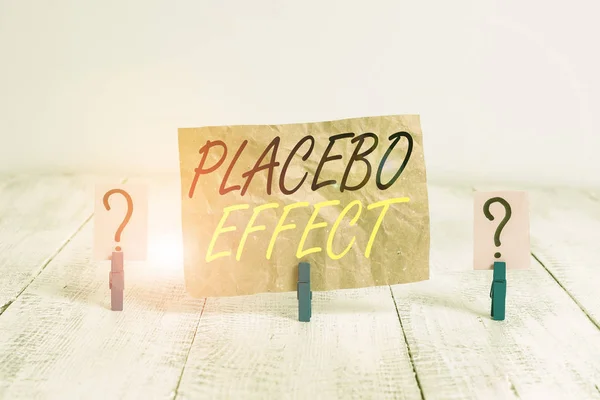 Texto escrito palavra Efeito Placebo. Conceito de negócio para um efeito benéfico produzido por uma droga placebo ou tratamento Folha crocante e desmoronada com clipes de papel colocados na mesa de madeira . — Fotografia de Stock