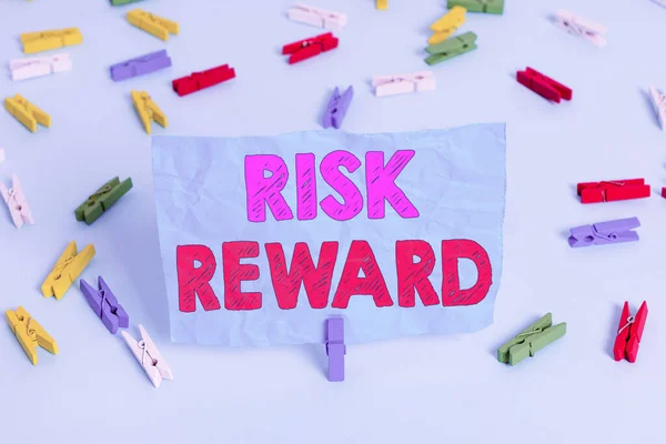 Word writing text Risk Reward. Business concept for assess the profit potential of a trade relative to its loss Colored clothespin papers empty reminder blue floor background office pin. — Stockfoto