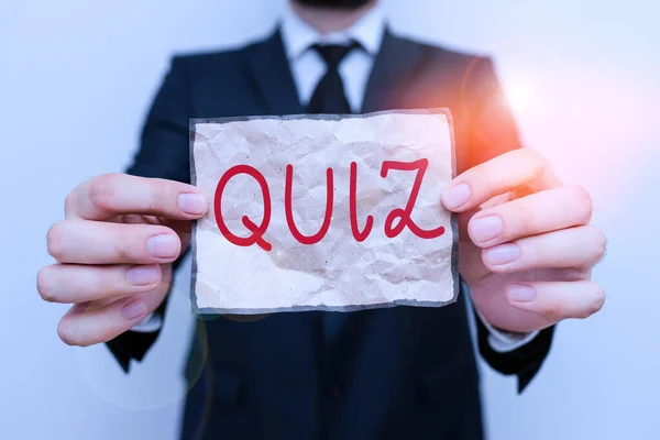 Word writing text Quiz. Business concept for Brief informal test given to students Test of knowledge Examination Male human wear formal work suit office look hold notepaper sheet use hand. — Stock Photo, Image