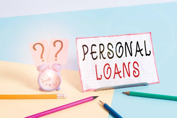 Text sign showing Personal Loans. Conceptual photo unsecured loan and helps you meet your financial needs Mini size alarm clock beside stationary placed tilted on pastel backdrop.