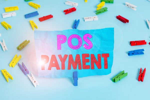 Word writing text Pos Payment. Business concept for customer tenders payment in exchange for goods and services Colored clothespin papers empty reminder blue floor background office pin.