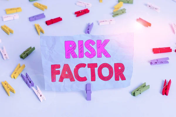 Word writing text Risk Factor. Business concept for a condition behavior or other factor that increases danger Colored clothespin papers empty reminder blue floor background office pin.