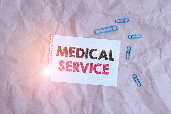 Conceptual hand writing showing Medical Service. Business photo showcasing treat illnesses and injuries that require medical response Papercraft desk square spiral notebook office study supplies. — Zdjęcie stockowe