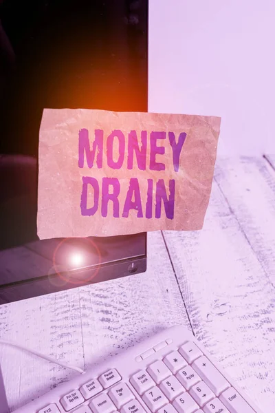 Writing note showing Money Drain. Business photo showcasing To waste or squander money Spend money foolishly or carelessly Notation paper computer monitor screen near white keyboard.