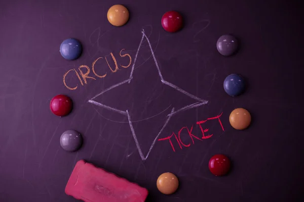 Texto manuscrito Circus Ticket. Concepto que significa tarjeta que da al titular un cierto derecho a entrar en el circo Redondo piedras de forma plana con una goma de borrar a la vieja pizarra de tiza negro . —  Fotos de Stock