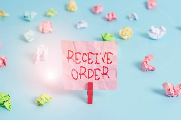 Writing note showing Receive Order. Business photo showcasing delivered and receive goods or services under specified terms Colored crumpled rectangle shaped reminder paper light blue background.