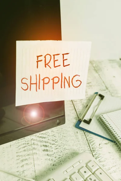 Writing note showing Free Shipping. Business photo showcasing directly deliver to the recipient address without charge Note paper taped to black computer screen near keyboard and stationary. — Stockfoto