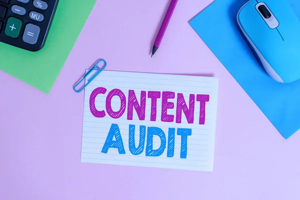 Writing note showing Content Audit. Business photo showcasing process of evaluating content elements and information Electronic mouse calculator paper sheets clip marker colored background. — Stock Photo, Image
