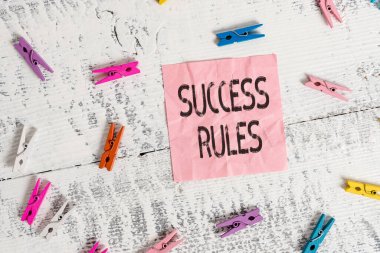 Handwriting text Success Rules. Concept meaning able to achieve all the goals that you have set for yourself Colored clothespin rectangle square shaped paper white wood background.