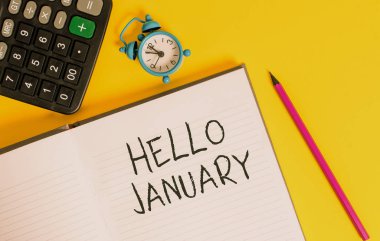 Writing note showing Hello January. Business photo showcasing a greeting or warm welcome to the first month of the year Open striped notebook calculator metal alarm clock color background.