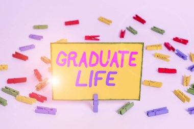Writing note showing Graduate Life. Business photo showcasing condition or a status a demonstrating after finishing academic degree Colored clothespin papers empty reminder white floor background