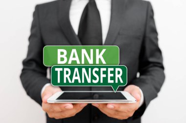 Conceptual hand writing showing Bank Transfer. Business photo showcasing when the money is sent from one bank account to another Male human wear formal work suit hold hitech smartphone.