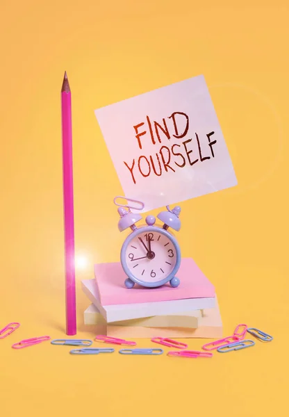 Writing note showing Find Yourself. Business photo showcasing To become selfsufficient and do things for yourself Alarm clock sticky note stacked notepads pencil colored background. — Zdjęcie stockowe