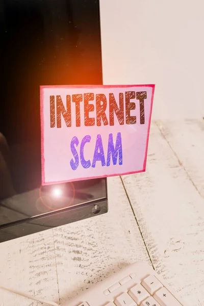 Conceptual hand writing showing Internet Scam. Business photo text type of fraud or scam which makes use of the Internet Notation paper computer monitor screen near white keyboard. — Stock fotografie
