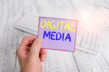 Kelime yazma metni Dijital Ortam. İnternet üzerinden iletilebilen sayısallaştırılmış içerik için iş konsepti renkli hatırlatıcı kare şeklindeki kağıt beyaz klavye ahşap zemin.
