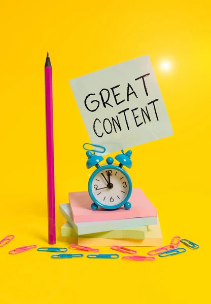 Writing note showing Great Content. Business photo showcasing valuable text matter of a document or publication in any form Alarm clock sticky note stacked notepads pencil colored background. — Stock Photo, Image