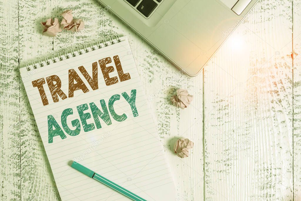 Conceptual hand writing showing Travel Agency. Business photo showcasing Agency that makes the necessary arrangements for travelers Laptop ruled spiral notepad crushed paper balls wooden table.