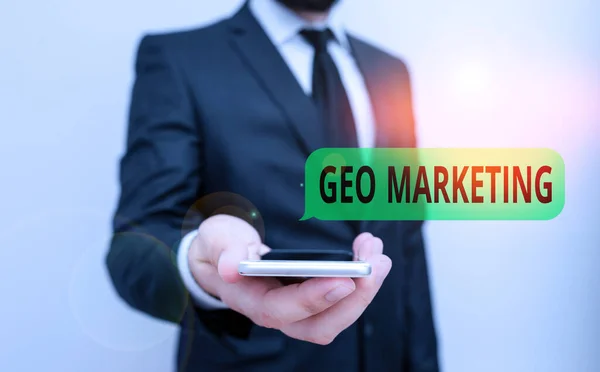 Word writing text Geo Marketing. Business concept for the geolocated marketing techniques to get new clients Male human wear formal work suit hold smart hi tech smartphone use one hand. — Stockfoto