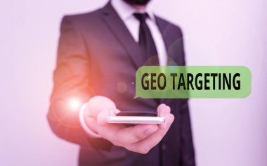 Kelime yazma metni Geo Hedefleme. Bir web sitesi ziyaretçisinin konumunu belirlemek için iş konsepti. Erkek giyimi resmi iş kıyafeti. Akıllı yüksek teknoloji akıllı telefon kullan..