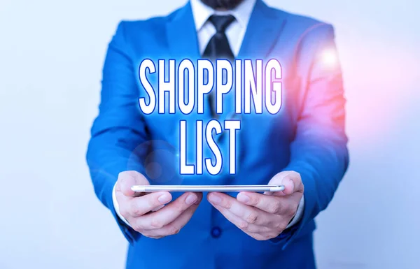 Word writing text Shopping List. Business concept for a list of items to be considered or purchases to be made Businessman in blue suite with a tie holds lap top in hands.