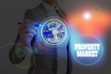 Writing note showing Property Market. Business photo showcasing the buying and selling of land and buildings Estate market Elements of this image furnished by NASA.